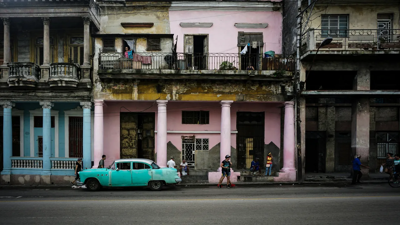 Old American car parked in front of an old building. Photo by Giacomo Buzzao